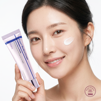Model holding the cream with a dab applied to her cheek