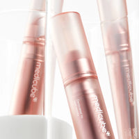 Close-up of the Milk Serum pen and Night Wrapping Mask tube