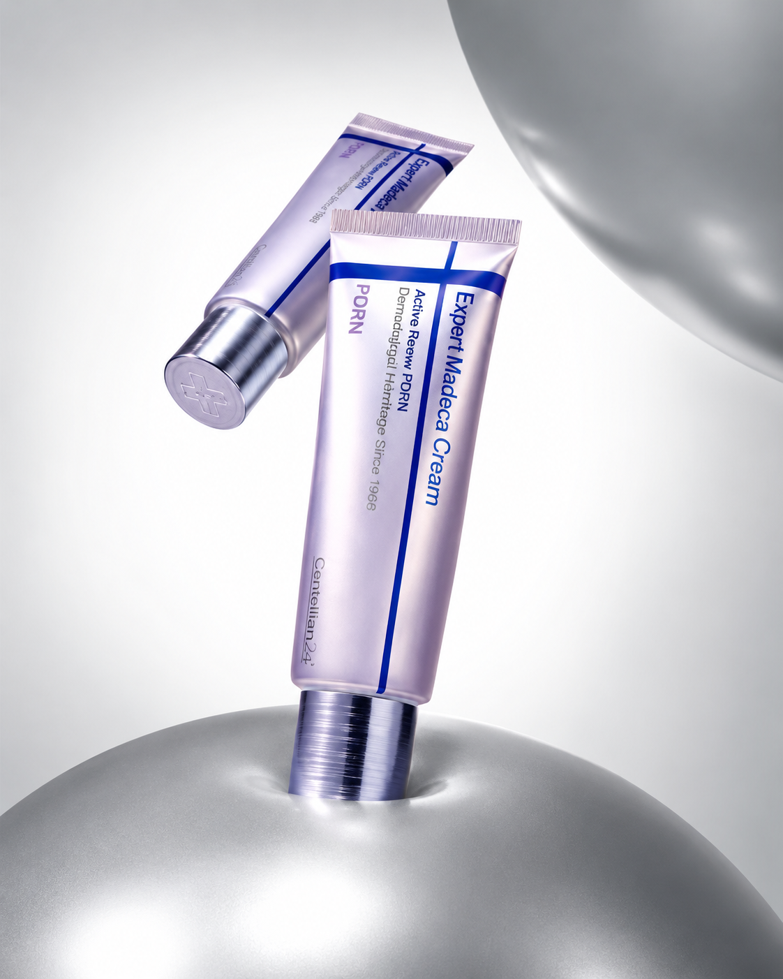 The cream tube resting against a polished steel sphere