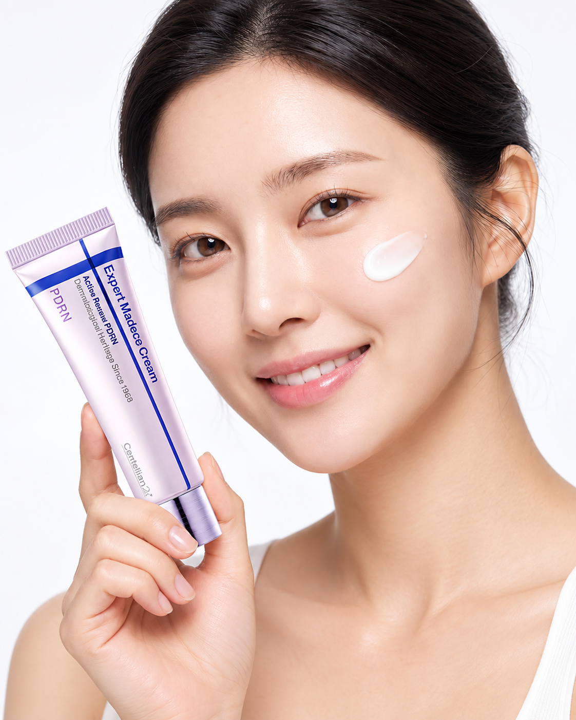 Model holding the Expert Madeca Cream with a dab applied to her cheek