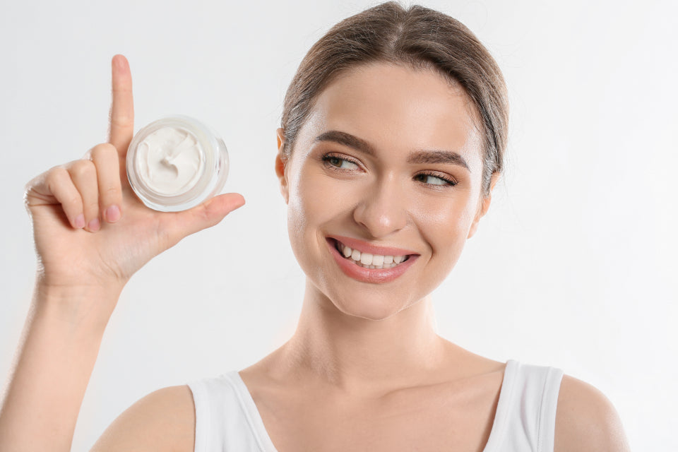 Woman holding a small jar of moisturiser